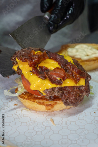 cheef making a hamburger doble with cheese and bacon photo