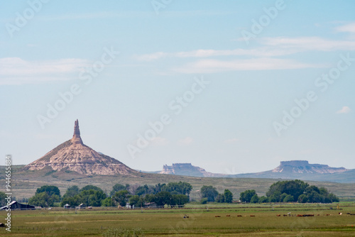 A distant view of Chimney Rock and Scotts Bluff National Monument in Nebraska under a clear blue sky