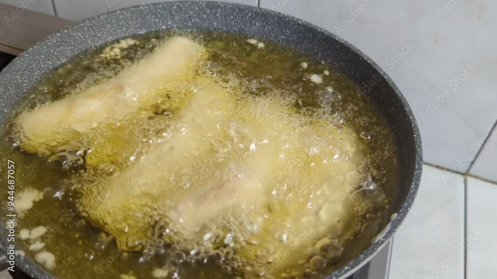 Cooking banana covered with flour being deep fried on hot oil in frying pan or skillet, High quality 4k footage Cooking banana covered with flour being deep fried on hot oil in frying pan or skillet, High quality 4k footage