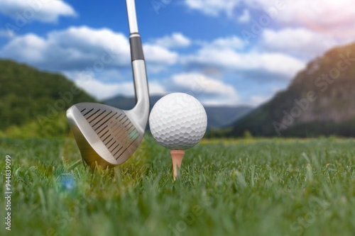 White golf balls, steel clubs on green grass photo