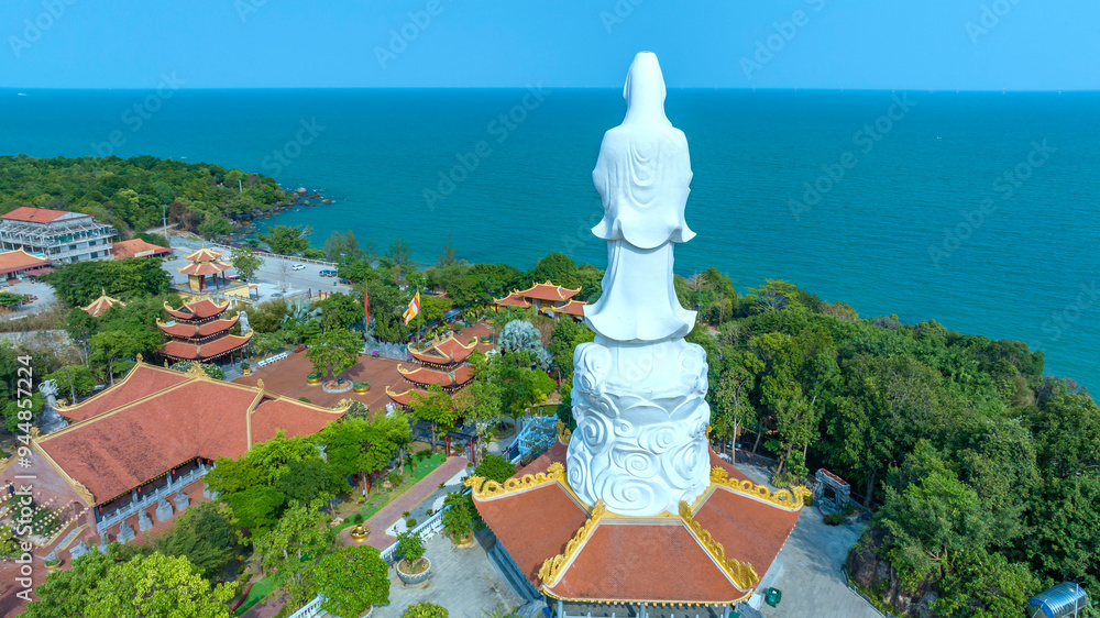 Fototapeta premium Aerial view of Ho Quoc pagoda in Phu Quoc island, Kien Giang, Vietnam, with Guan Yin statue overlooking the sea blessing the islanders with peace and happiness