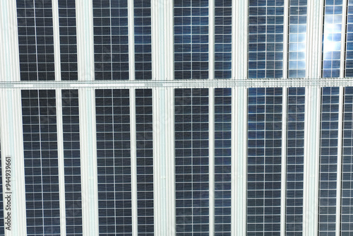 Solar energy for factory and warehouse building. Solar panels on roof of industrial plant. Commercial solar power. Rooftop solar power. Rooftop renewable energy system. Sustainable green energy.