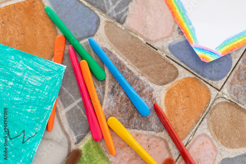 Wallpaper Mural A child is drawing with crayons on a table. The crayons are in a rainbow of colors and are scattered across the table. Torontodigital.ca