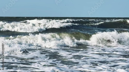 A child swims in the Sea of Azov. A boy jumps into the sea waves from the beach. The boy dives into the foaming wave. The delight of a child from a vacation at the sea. Happy moments with children. 4K photo