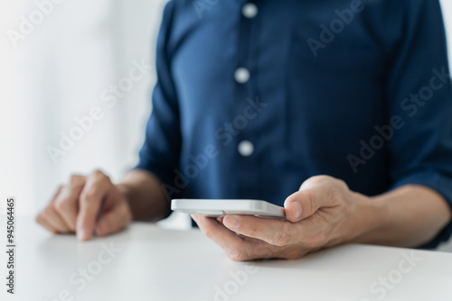 Businessman hand holding smartphone with blank screen display. Mobile phone mockup device with copy space for text content, information message.