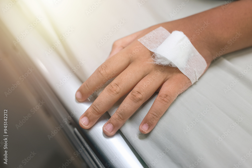 Close up child hand with tube of normal saline infusion at the hospital because it is influenza A. Hand of a patient in Hospital ward. Concept about treatment, emergency, medical, chemotherapy, sick. Close up child hand with tube of normal saline infusion at the hospital because it is influenza A. Hand of a patient in Hospital ward. Concept about treatment, emergency, medical, chemotherapy, sick.