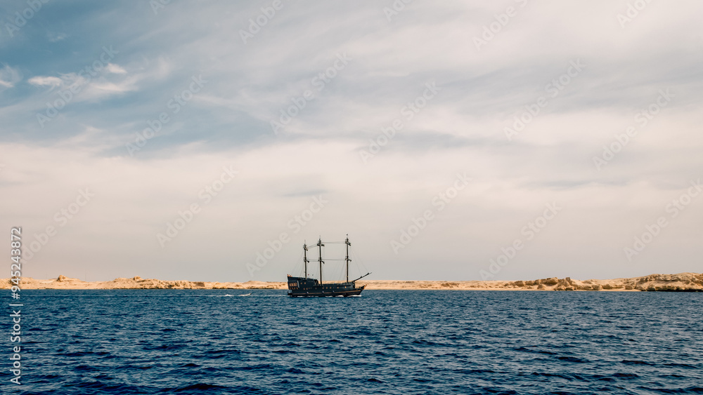 black yacht near the rocky shore of the Red Sea black yacht near the rocky shore of the Red Sea