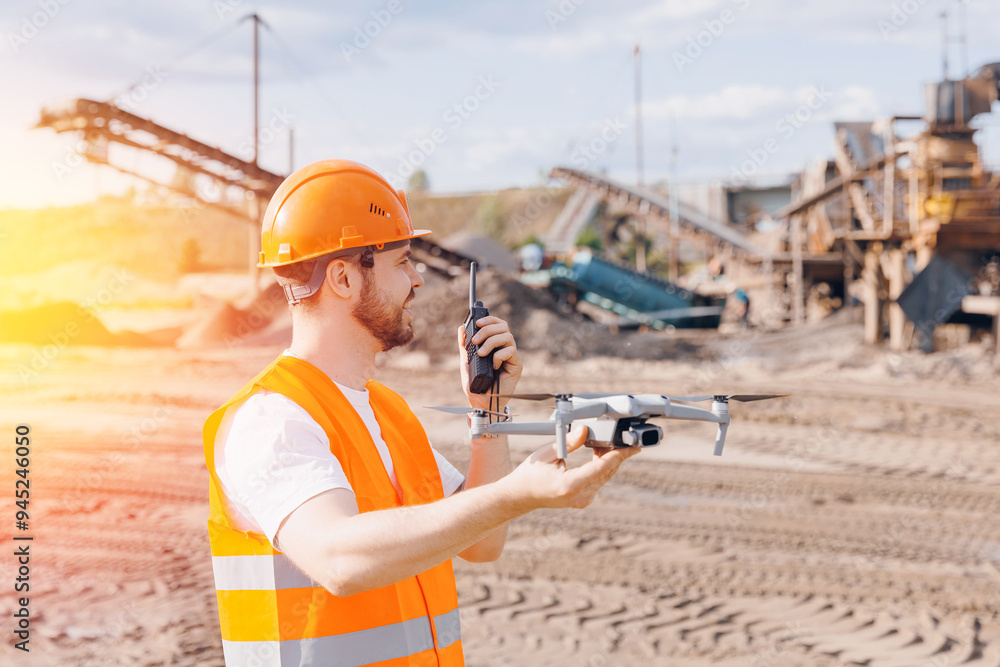 Man engineer launches drone for control sand quarry construction site. Concept industry equipment fly robot. Man engineer launches drone for control sand quarry construction site. Concept industry equipment fly robot.