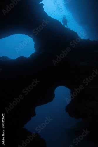 View from a Cathedral cave (Pescador Island, Philippines) with a distant silhouette of a scuba diver