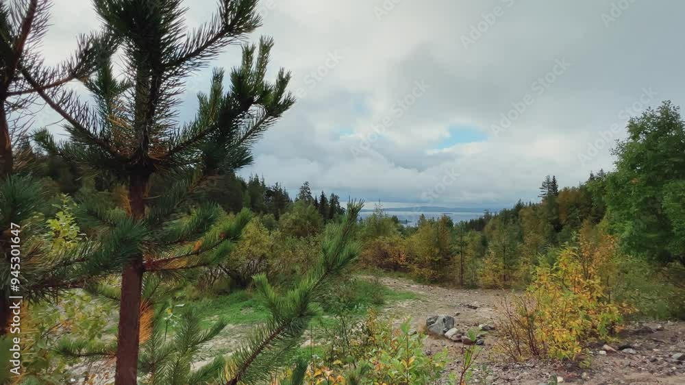 A cloudy day in the Murmansk region. Beautiful autumn view of the Kandalaksha Bay of the White Sea. Sunset on the White Sea coast in northern Russia.The sun is setting behind the sea and the mountains A cloudy day in the Murmansk region. Beautiful autumn view of the Kandalaksha Bay of the White Sea. Sunset on the White Sea coast in northern Russia.The sun is setting behind the sea and the mountains