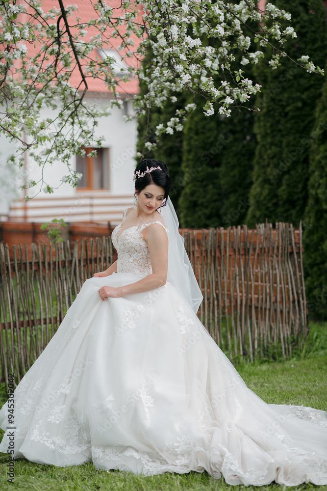 A woman in a white wedding dress is standing in a field of flowers. She is wearing a veil and a necklace A woman in a white wedding dress is standing in a field of flowers. She is wearing a veil and a necklace