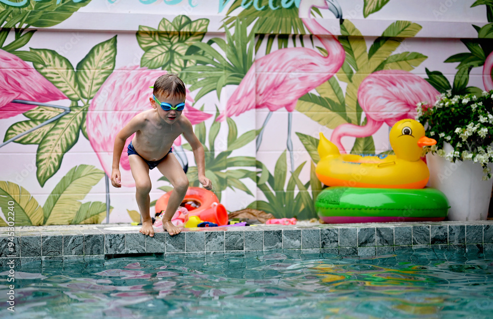 Naklejka premium Boy has fun in swimming pool