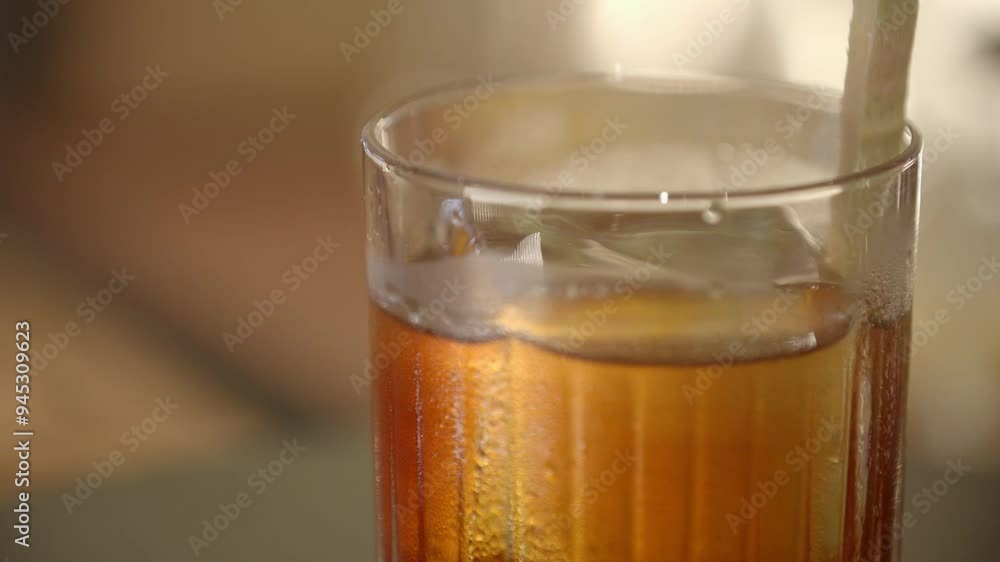 Close up of Glass of Alcohol with Large Ice Cube and Lemongrass Close up of Glass of Alcohol with Large Ice Cube and Lemongrass