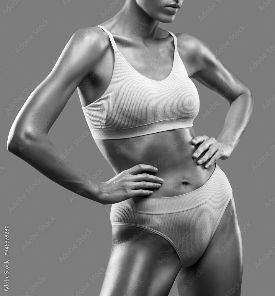 Fototapeta premium A slender swarthy woman in beige underwear on a isolated background. Healthy lifestyle, sport and diet.