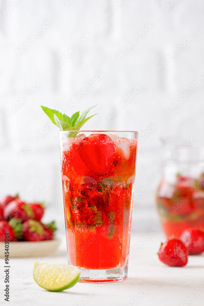 Fresh cocktail with strawberries, mint and lime in a glass. Strawberry mojito. Refreshing red drink, sugar free. Vertical orientation. Fresh cocktail with strawberries, mint and lime in a glass. Strawberry mojito. Refreshing red drink, sugar free. Vertical orientation.