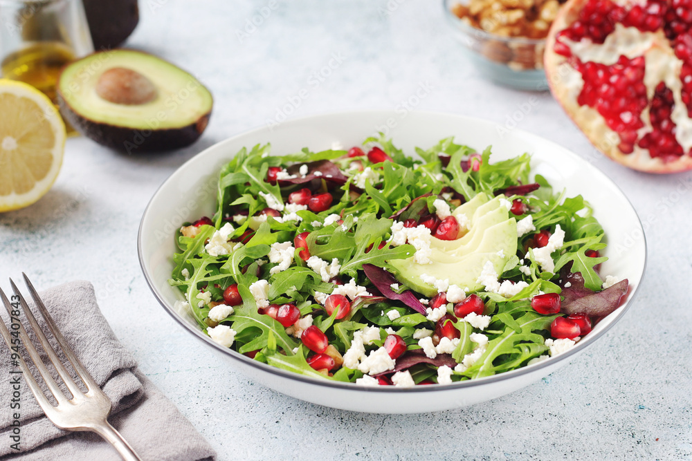 A plate with green rocket salad with pomegranate and avocado A plate with green rocket salad with pomegranate and avocado