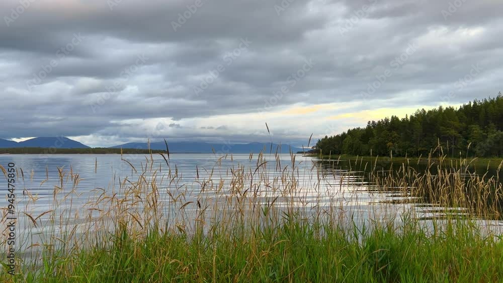 A cloudy day in the Murmansk region. Beautiful autumn view of the Kandalaksha Bay of the White Sea. Sunset on the White Sea coast in northern Russia.The sun is setting behind the sea and the mountains A cloudy day in the Murmansk region. Beautiful autumn view of the Kandalaksha Bay of the White Sea. Sunset on the White Sea coast in northern Russia.The sun is setting behind the sea and the mountains