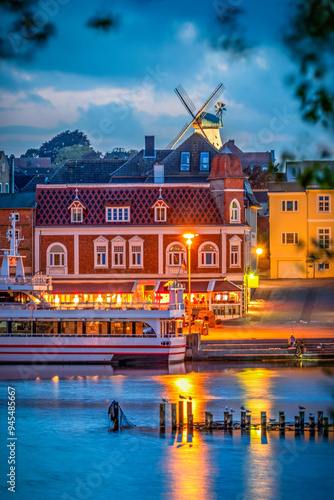 View to some buildings at the riverbank of river Schlei in the small city of Kappeln in Germany at blue hour