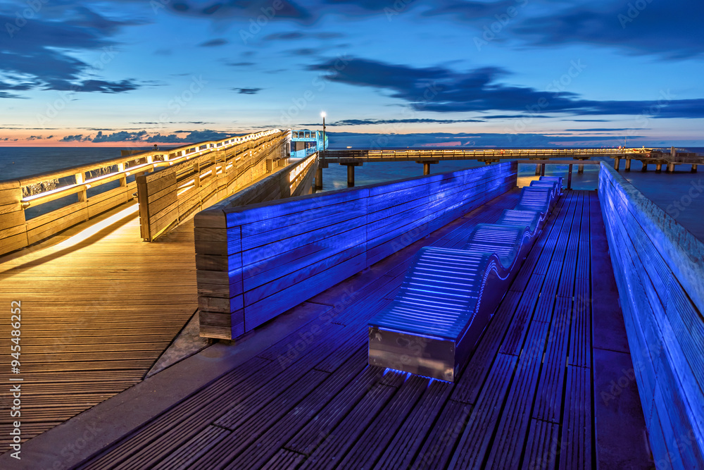 Fototapeta premium Part of the wooden pier of German city Heiligenhafen at the Baltic Sea at blue hour