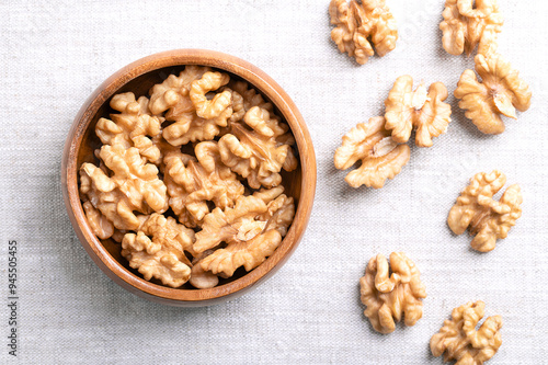 Photos Walnut kernel halves in a wooden bowl on linen fabric