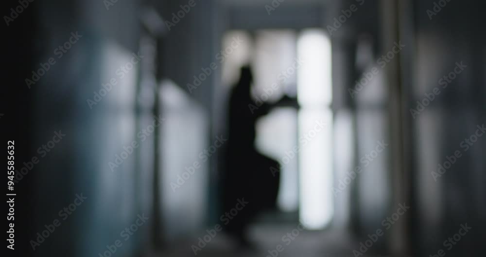 Blurred shot of a grim reaper dancing with a scythe in the dark corridor. This creepy and fun scene blends fear and horror. Halloween night. Funny dance of a figure in a death costume. Blurred shot of a grim reaper dancing with a scythe in the dark corridor. This creepy and fun scene blends fear and horror. Halloween night. Funny dance of a figure in a death costume.
