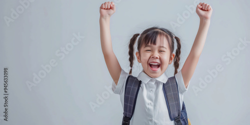 Happy Schoolgirl Celebrating Success with Raised Hands and Backpack photo