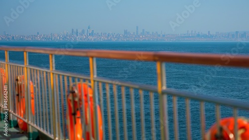  Sea of Marmara view from the ferry over the railing of a ship with attached orange lifebuoys. Istanbul cityscape on the horizon. 