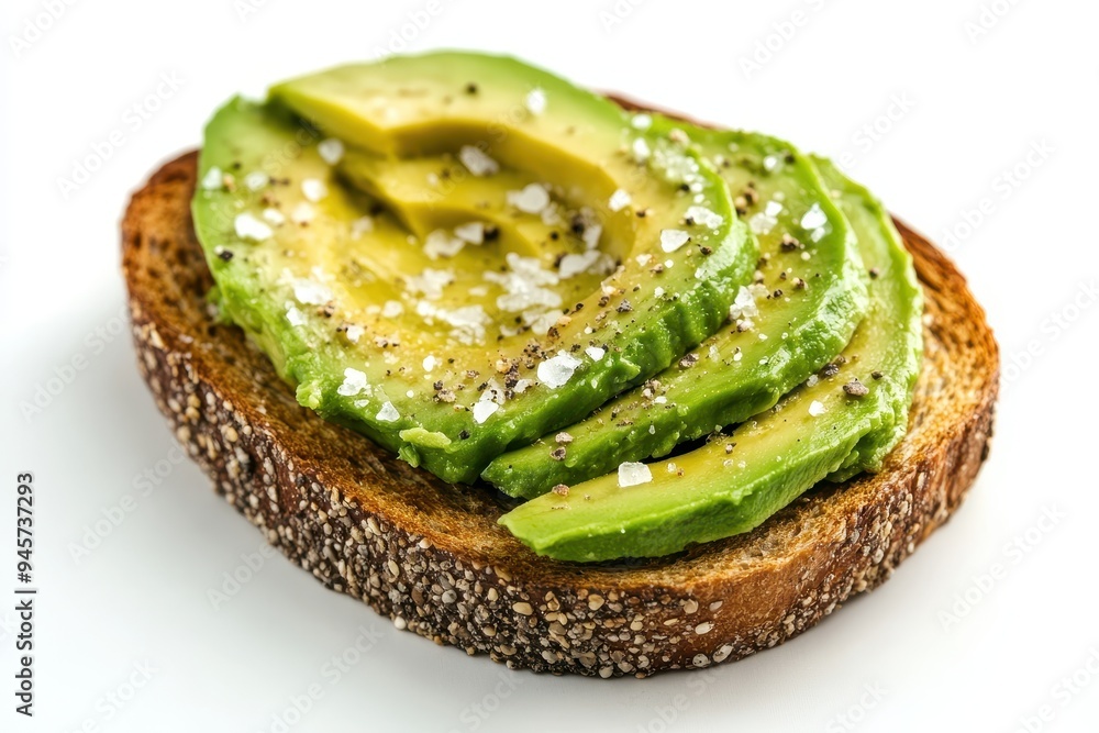 A slice of toasted bread topped with avocado slices and sprinkled with salt and pepper. A slice of toasted bread topped with avocado slices and sprinkled with salt and pepper.