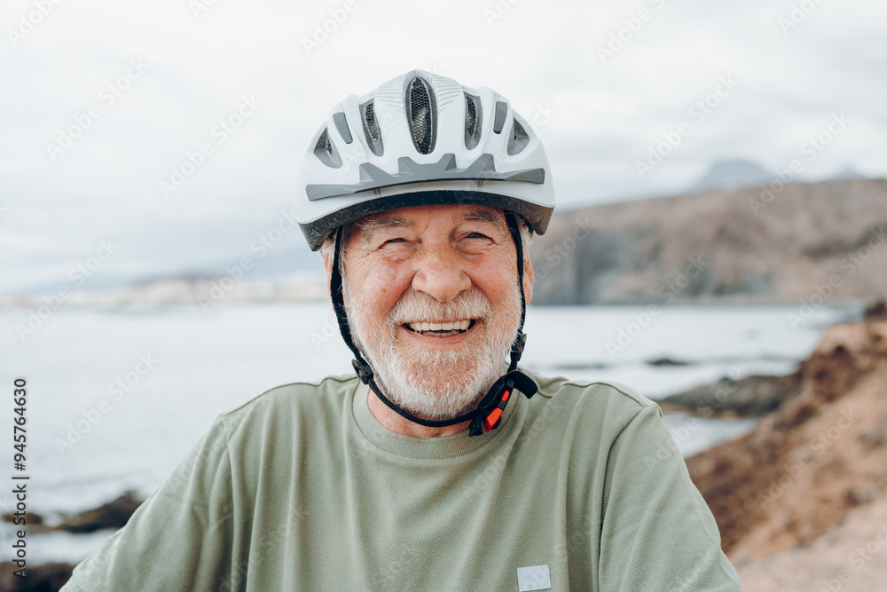 One happy cheerful active senior man looking at the camera smiling and enjoying wearing bike helmet for safety. Healthy lifestyle concept exercising riding bike outdoors One happy cheerful active senior man looking at the camera smiling and enjoying wearing bike helmet for safety. Healthy lifestyle concept exercising riding bike outdoors