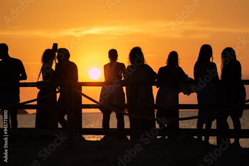 Silhouetted people watching the sunset photo