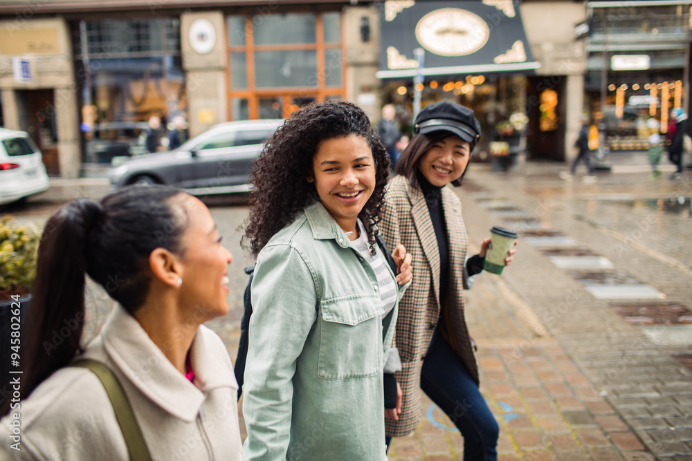 Three diverse female friends walking together on city street Three diverse female friends walking together on city street