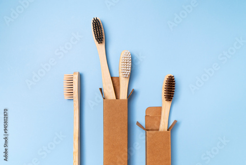 Eco-friendly dental wooden bamboo toothbrushes on plain blue background. Dental care and health, plastic-free life, zero waste, save the planet. Flat lay top view copy space