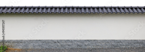 Long Japanese style fence with granite base and black tiles on top isolated