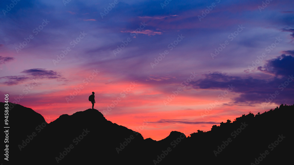 Silhouette of young traveler with backpack watched sky at sunset alone on top of the mountain. He enjoyed traveling and was successful when he reached the summit. Silhouette of young traveler with backpack watched sky at sunset alone on top of the mountain. He enjoyed traveling and was successful when he reached the summit.