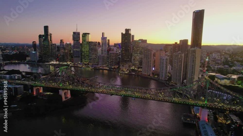 Aerial view of brisbane river with story bridge and illuminated skyline at dusk, brisbane, australia. photo