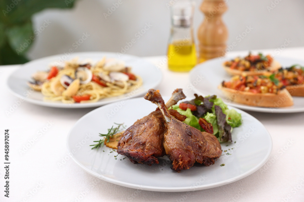 Duck leg confit with sauce. isolate in white background. top view. Duck confit on white plate Duck leg confit with sauce. isolate in white background. top view. Duck confit on white plate