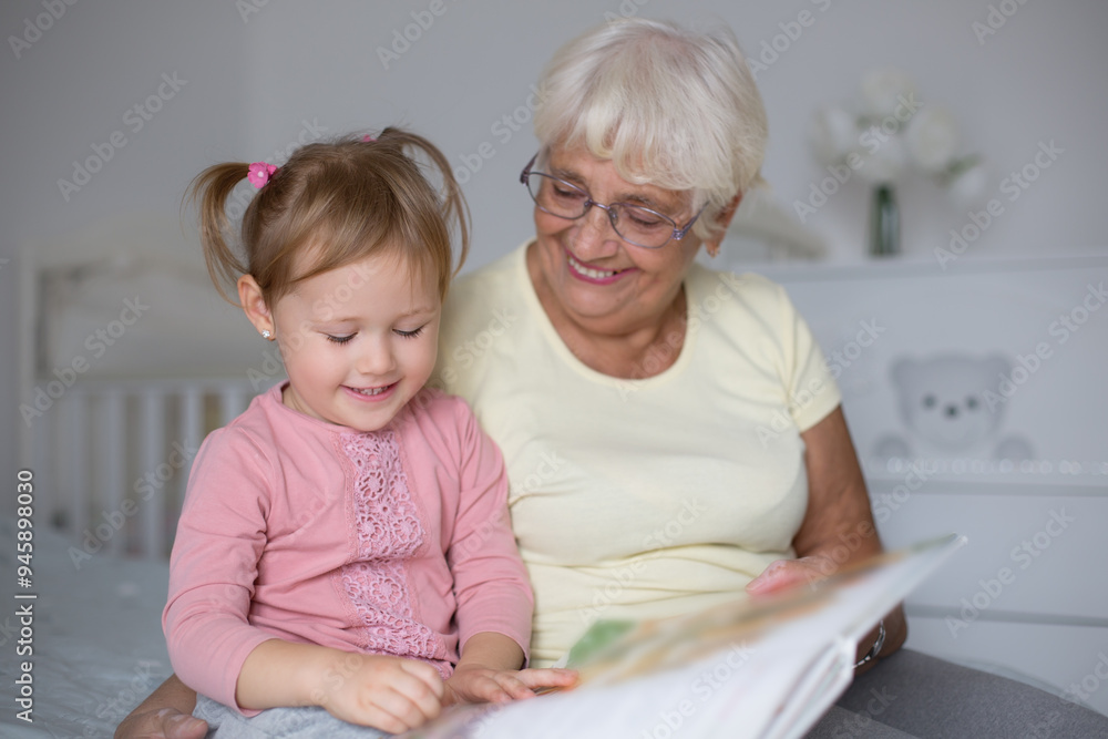 Closeup photo of Grandmother teaches to read a book her granddaughter,Family concept Closeup photo of Grandmother teaches to read a book her granddaughter,Family concept