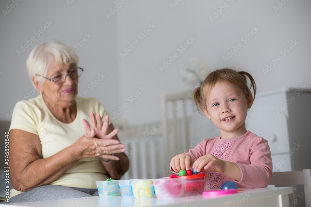 Grandmother and small girl making figures from play dough