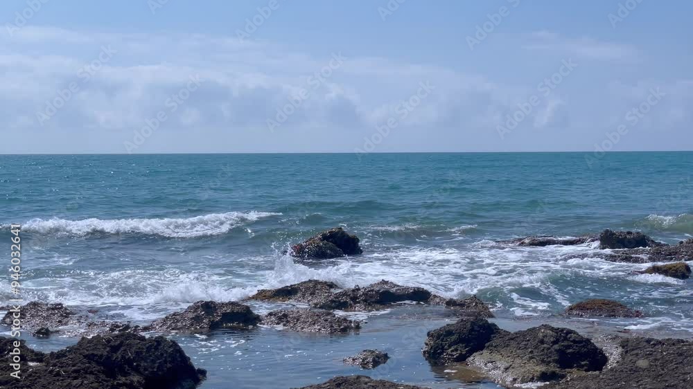Waves crash against rocks at beach, sea spray in air, sunlight reflects on water. Natural ocean wave motion, hit rough stone coast in evening. Nature scene for calm, travel, atmosphere. 4k footage Waves crash against rocks at beach, sea spray in air, sunlight reflects on water. Natural ocean wave motion, hit rough stone coast in evening. Nature scene for calm, travel, atmosphere. 4k footage