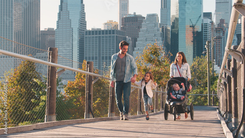 Family Day Out In New York City With Mum Pushing Baby In Buggy With Manhattan Skyline In Background