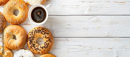 Different varieties of bagels and coffee Plain chocolate and spinach bagels A bright room featuring a white wooden table. Copy space image. Place for adding text and design photo