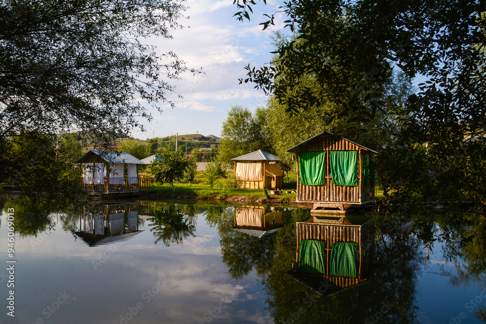 Obraz premium Wooden house by the lake. Cottage on the river bank. Cottage for rest. House in the forest