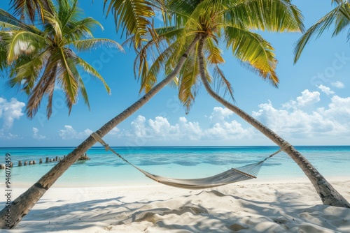 A serene hammock between palms on a beautiful sandy Maldive beach symbolizes summer vacation photo