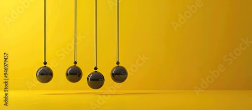 Newton s cradle against a yellow background with space for text The physics principle of energy conservation. Copy space image. Place for adding text and design