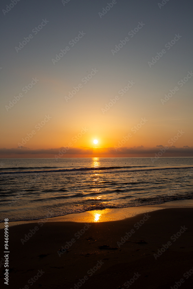 Sunrise over ocean horizon with looming stormy clouds above. Sunrise over ocean horizon with looming stormy clouds above.