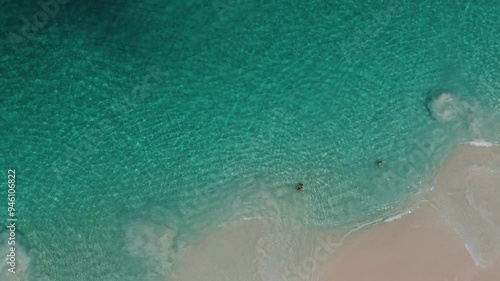 People chilling in transparent blue sea in Bahamas. Aerial view, top view.
