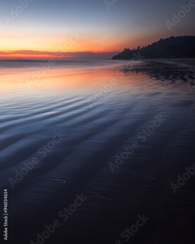 dawn colours reflected on beach water at minnie water on nsw north coast of australia