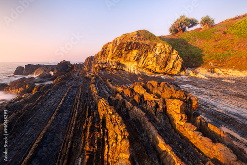 Papier peint golden sunrise light over rocks along coast at minnie water in nsw australia
