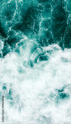 Aerial view of ocean waves creating a beautiful contrast of turquoise and white foam, perfect for nature and travel themes.