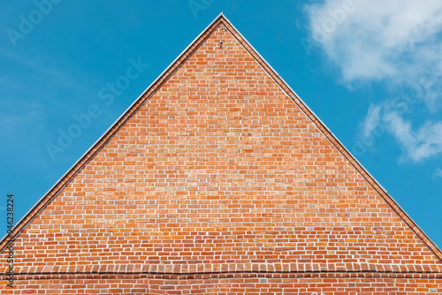 The top of the house with red brick and pointed roof 